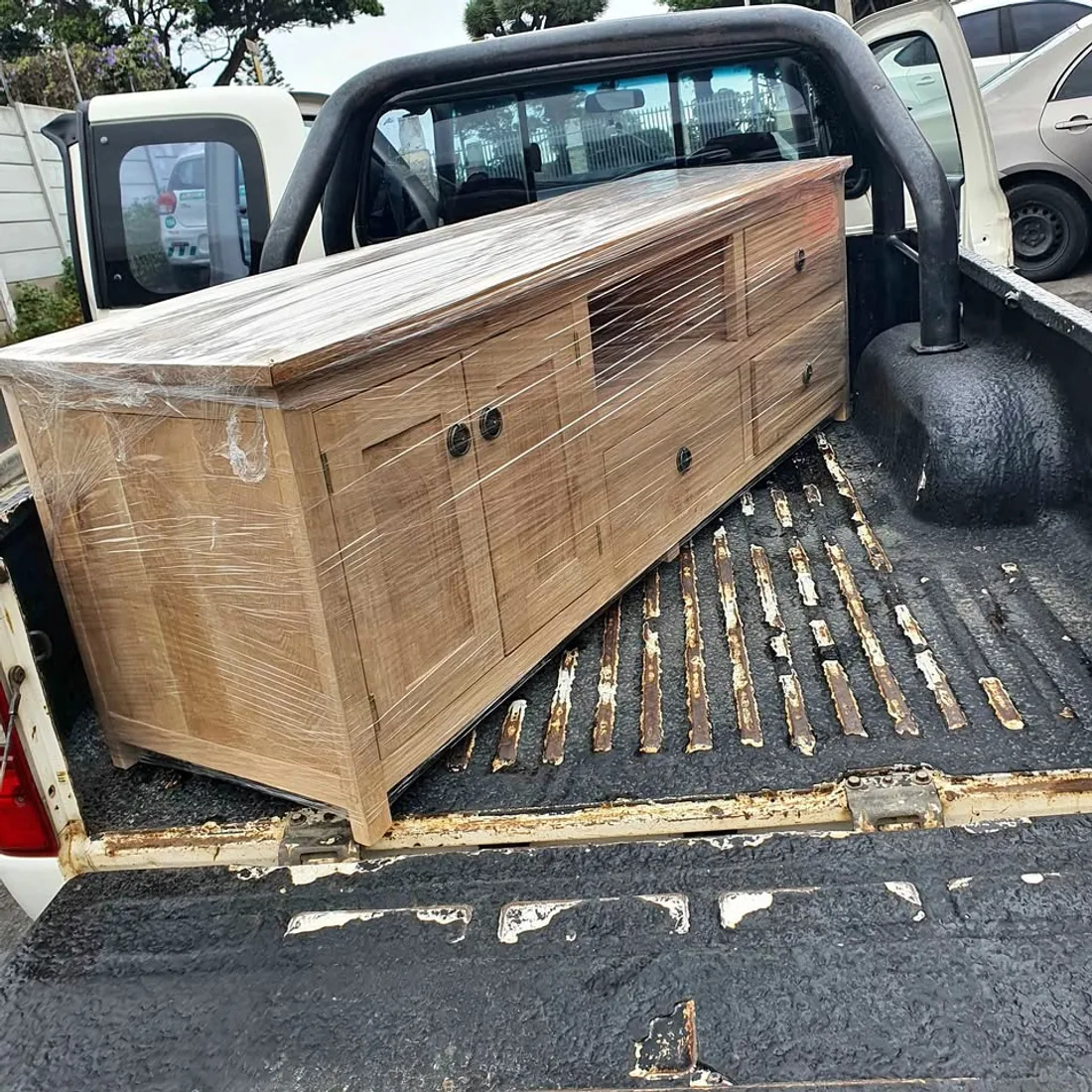 A TV stand wrapped and loaded on the back of a bakkie for delivery